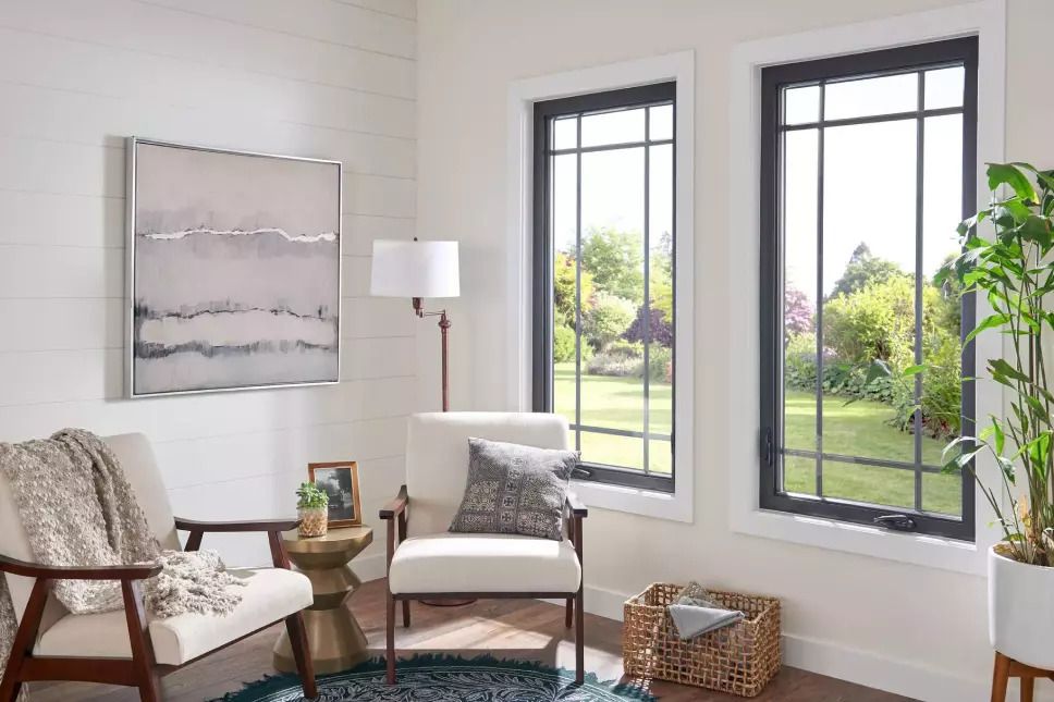 Living area of a home with two large casement windows with grids.