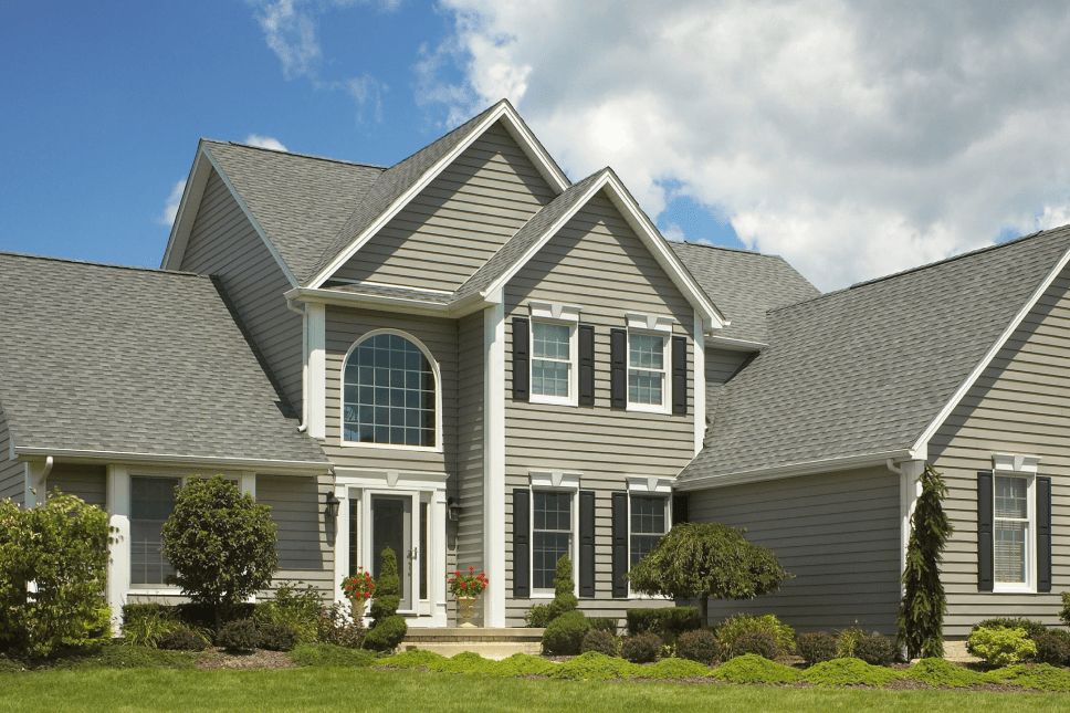 Front exterior of a two-story home with new vinyl siding in light gray.