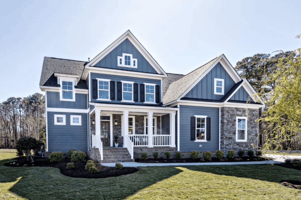 Two-story residential home with blue siding and white windows and trim.